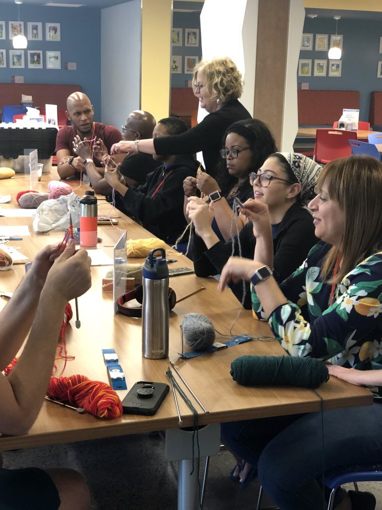 Families participating in a mindful knitting activity