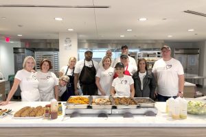 Volunteer Guest Chefs from Berkshire-Hathaway with food they cooked