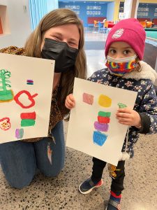 Staff with a guest childdrawings made during an activity