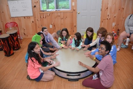 Campers playing on one big drum