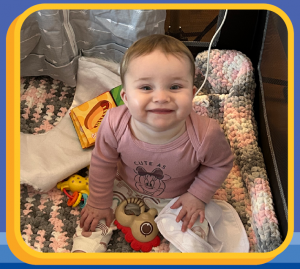 a young girl smiling in her pack and play