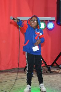 Camper asking the crowd to sing during talent show