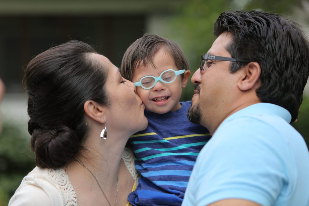 A mother and father embracing thir child